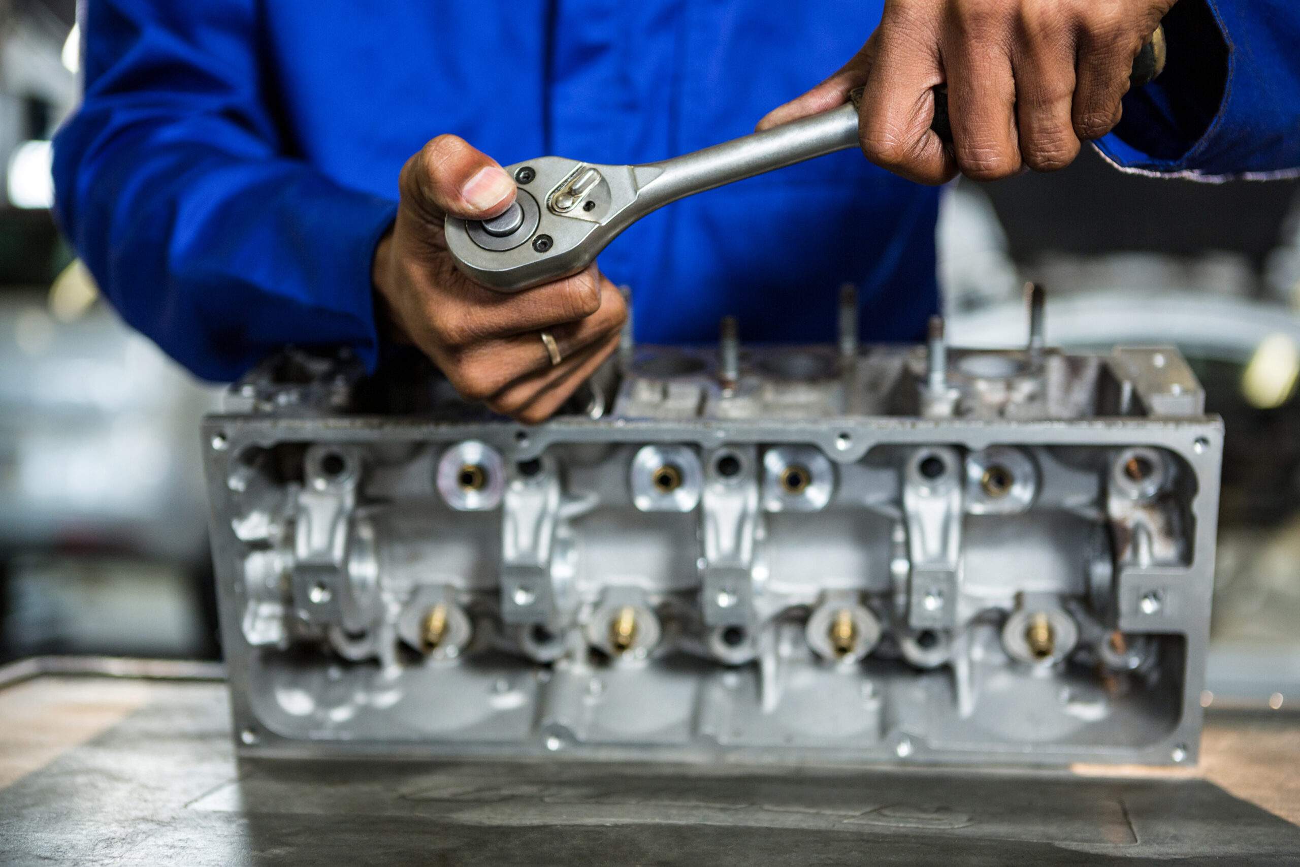 Mechanic repairing engine part with ratchet at the repair garage